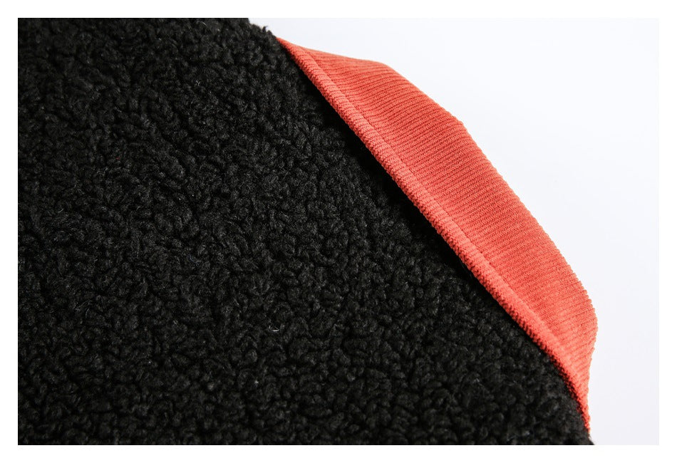Close-up of black textured fabric with a wide coral-red bound edge.