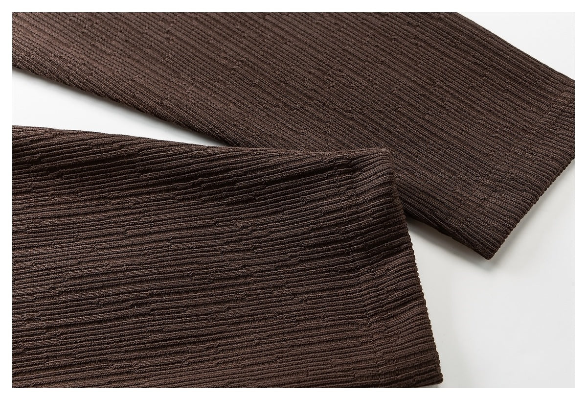 Close-up of the brown ribbed garment's sleeve and finished cuff.