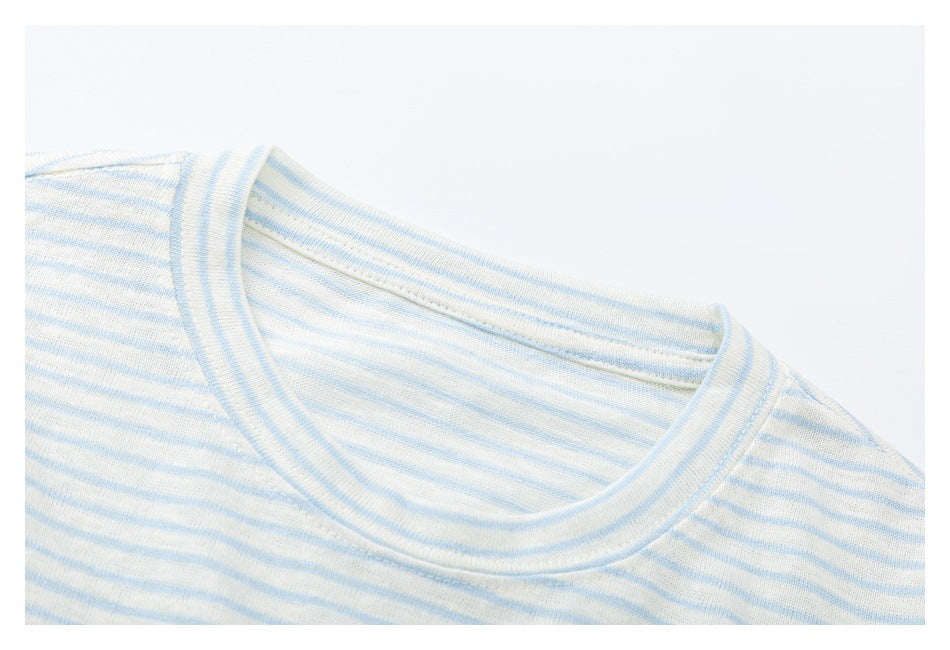 Close-up of the crew neckline and shoulder seams on a cream and pale blue striped shirt.