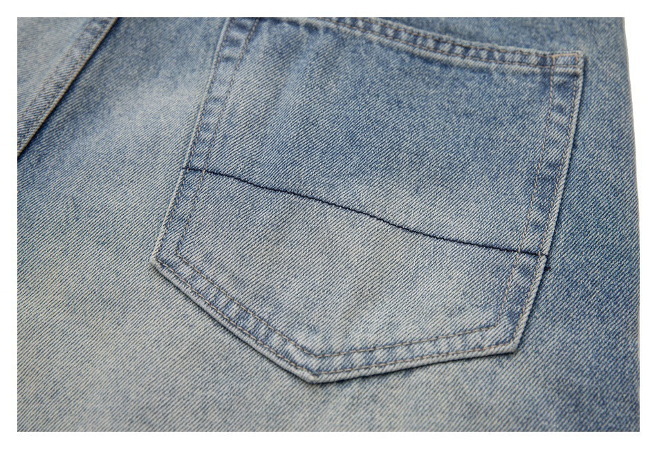 Close-up of a back pocket on faded light-blue jeans, with a dark horizontal stitch accent.