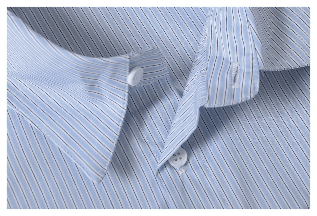Close-up of the light blue striped shirt's collar, placket, white buttons, and stitching.