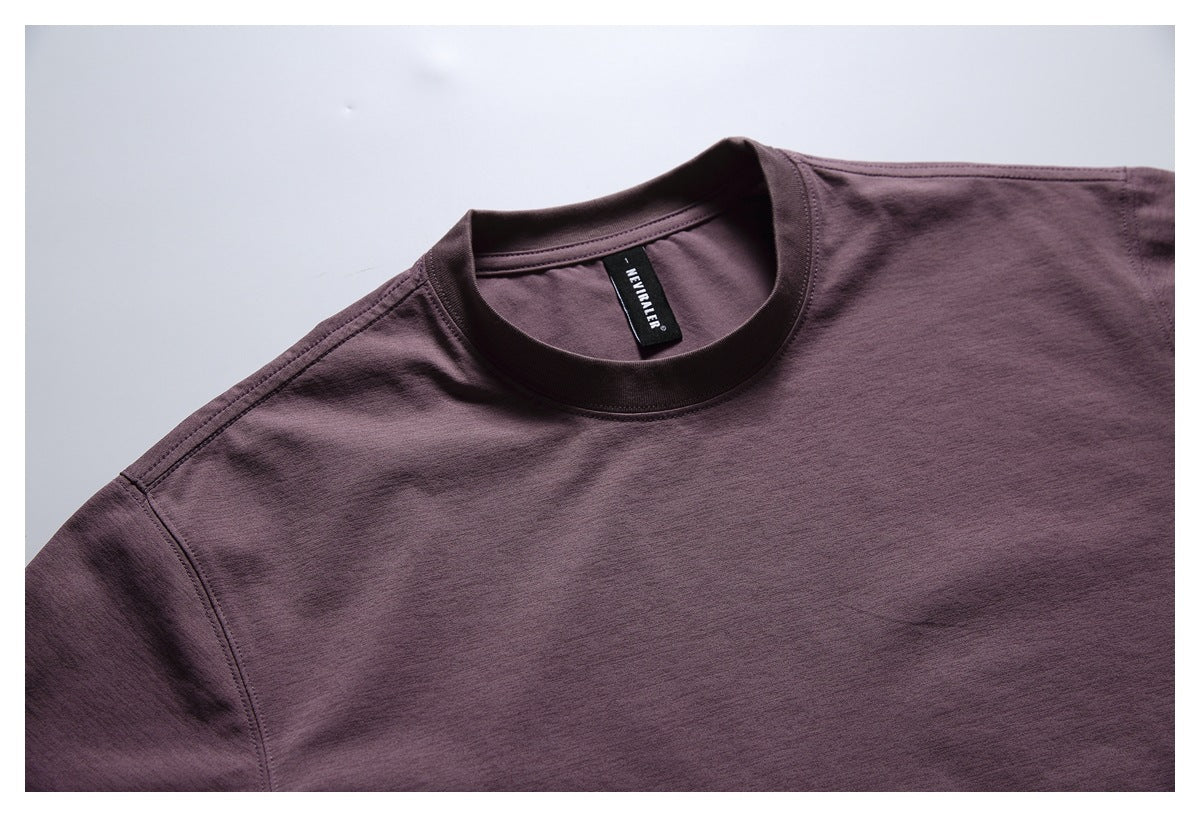 Close-up of a muted plum T-shirt's crew neckline, shoulder seams, and black neck label.