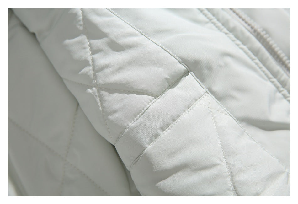 Close-up of the white jacket's quilted stitching and fabric panels.