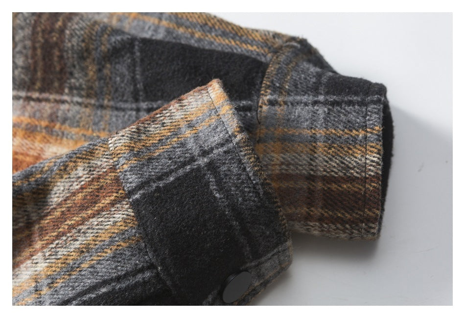 Close-up of a plaid garment cuff with a black snap button and matching plaid sleeve.