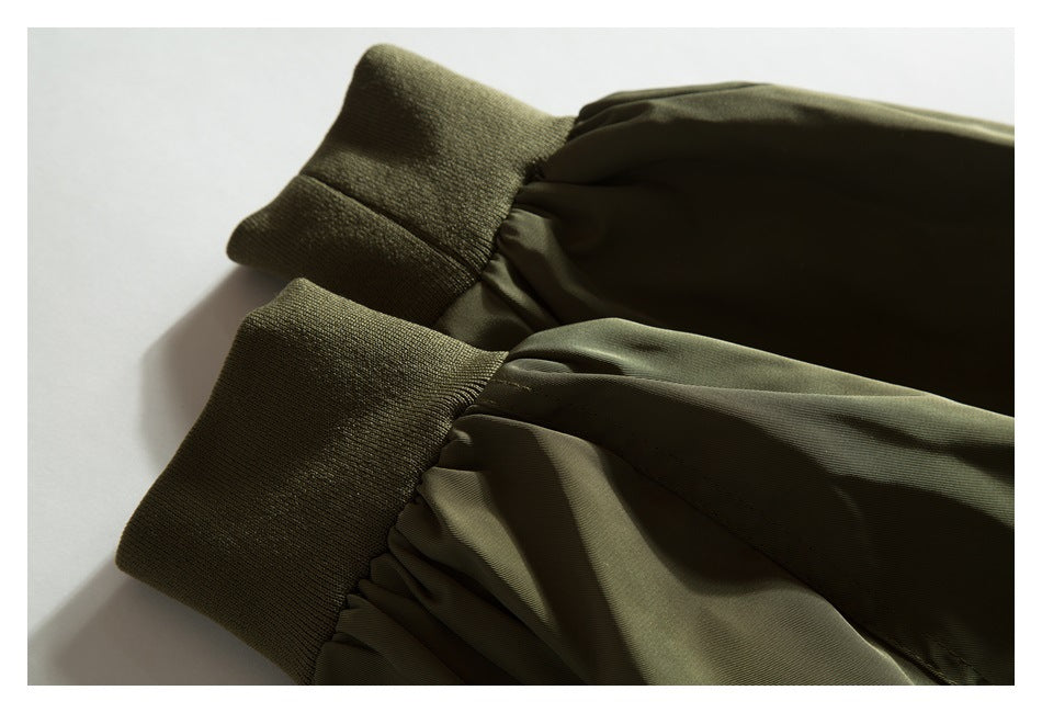 Close-up of an olive jacket sleeve gathered into a wide ribbed cuff.