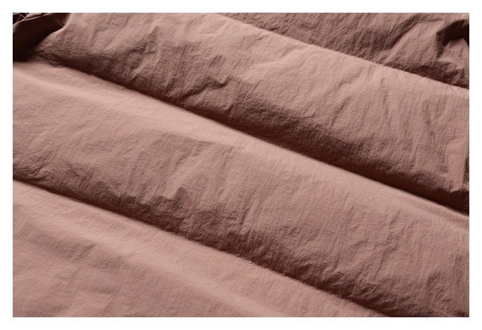 Close-up of overlapping brown fabric panels and their stitched seams.
