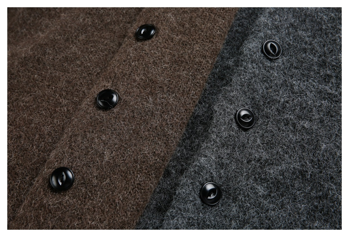 Close-up of brown and charcoal cardigan fabric with glossy black buttons.