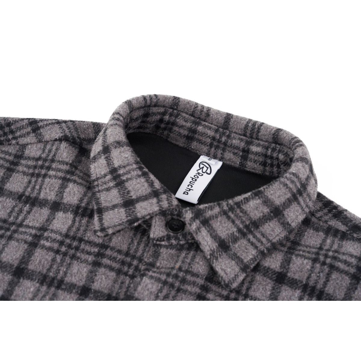Close-up of a gray and black plaid shirt collar with a black button and sewn-in neck label.