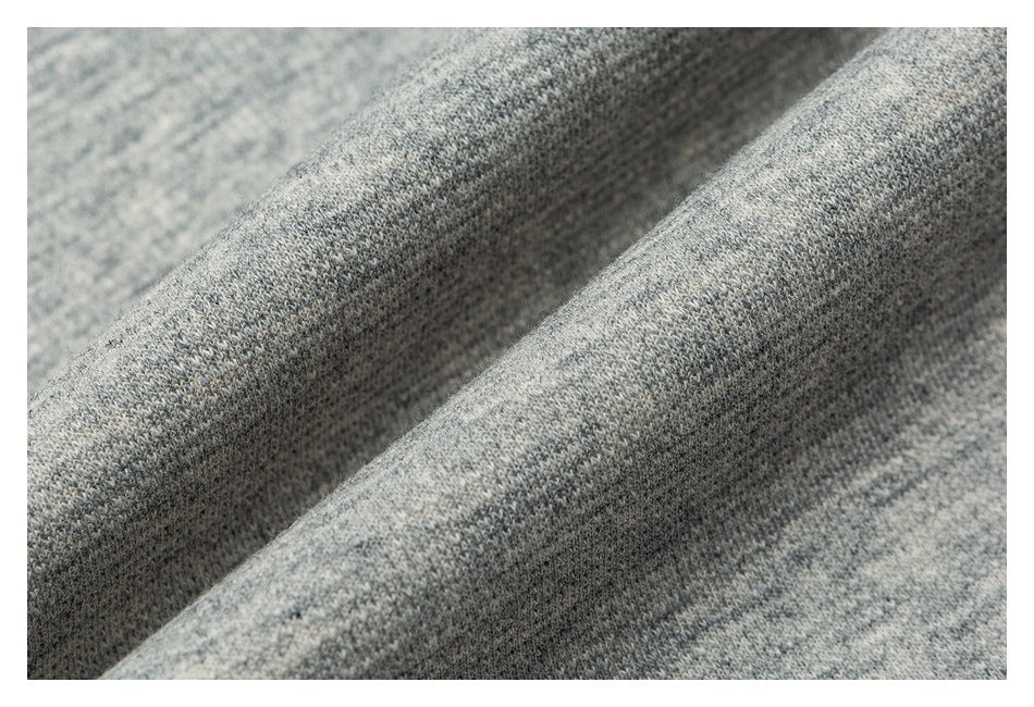 Macro view of the textured gray marl knit fabric, draped into soft folds.