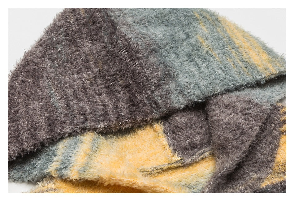 Close-up of folded fuzzy sweater fabric showing gray, brown, and mustard stripes.