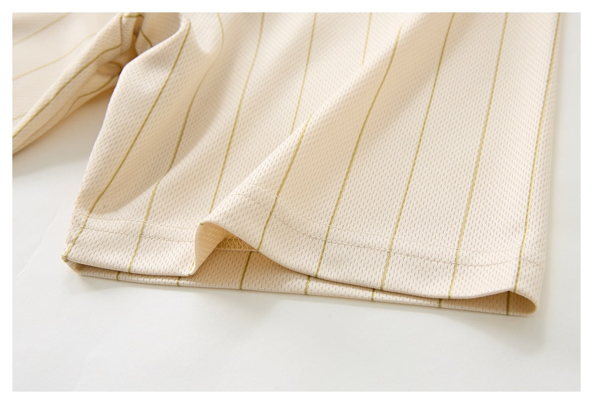 Close-up of the cream garment's pinstriped hem and stitched edge against a white background.