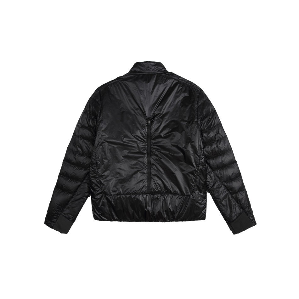 Back view of a black lightweight quilted jacket with a stand collar, center-back zipper, and elastic cuffs and hem.