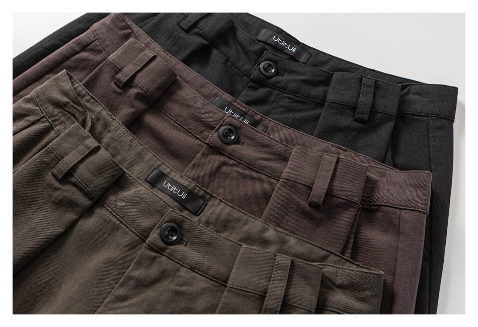 Three pairs of pleated, wide-leg trousers in black, brown and olive, shown overlapping from the waist down.