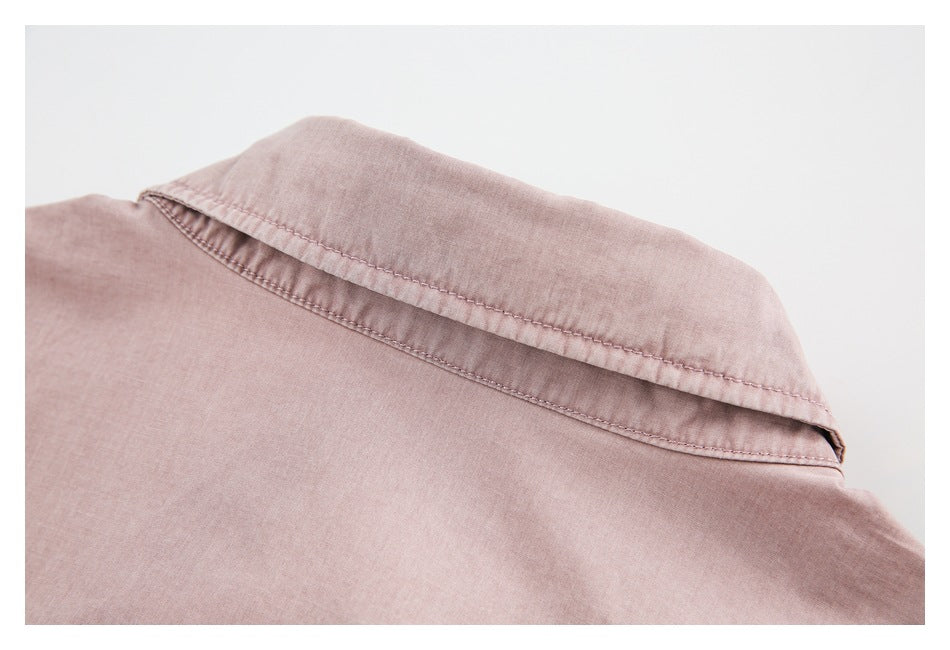 Close-up of the folded collar and topstitching on a dusty pink shirt.