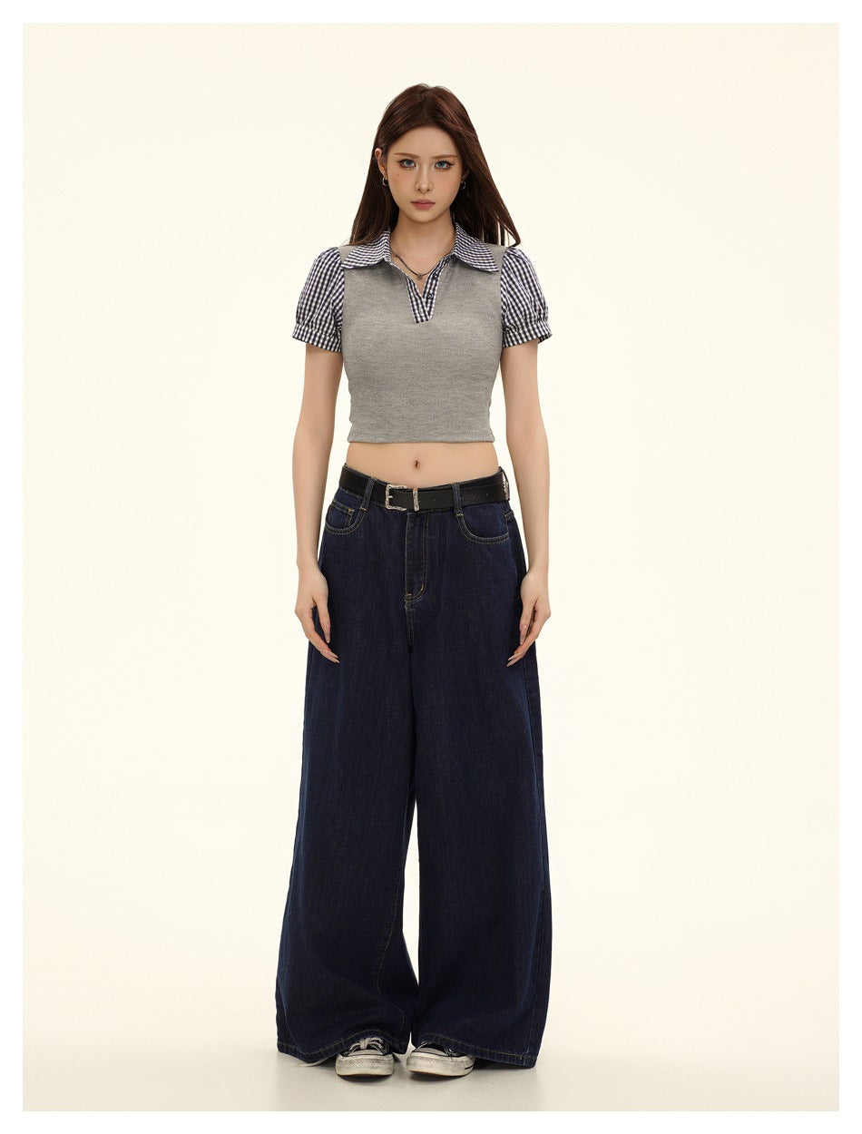 Model wearing gray cropped top with gingham collar and sleeves, wide-leg dark jeans and a black belt