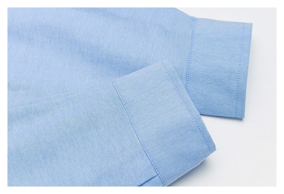 Close-up of the pale blue shirt’s sleeve cuff and folded fabric.
