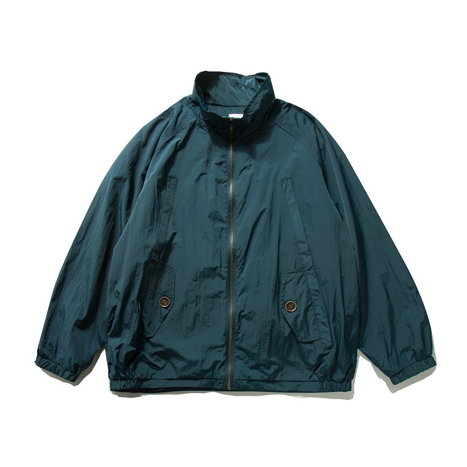 Blue-green zip-up jacket with stand collar, raglan sleeves, button flap pockets and elastic cuffs, flat front view
