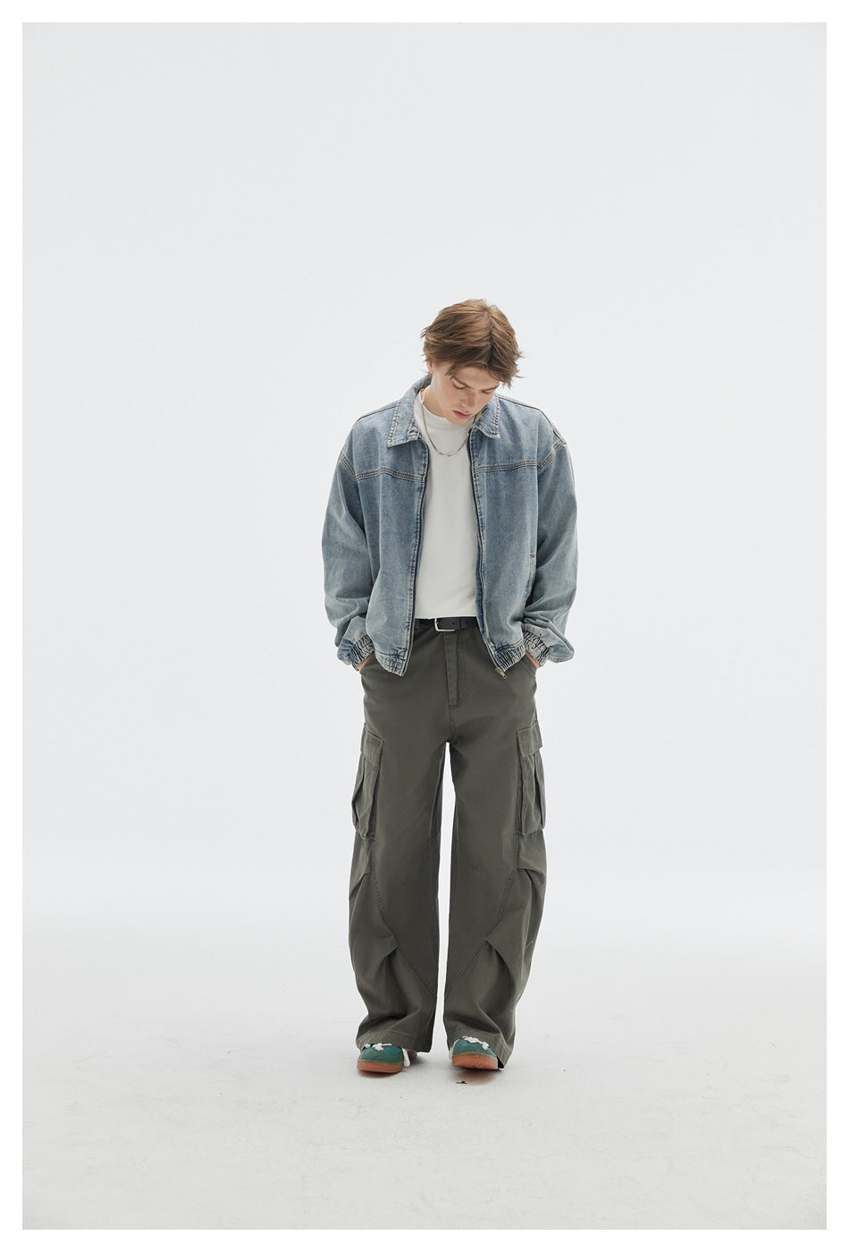 Model wearing an open light blue denim jacket over a white shirt with loose olive cargo pants.