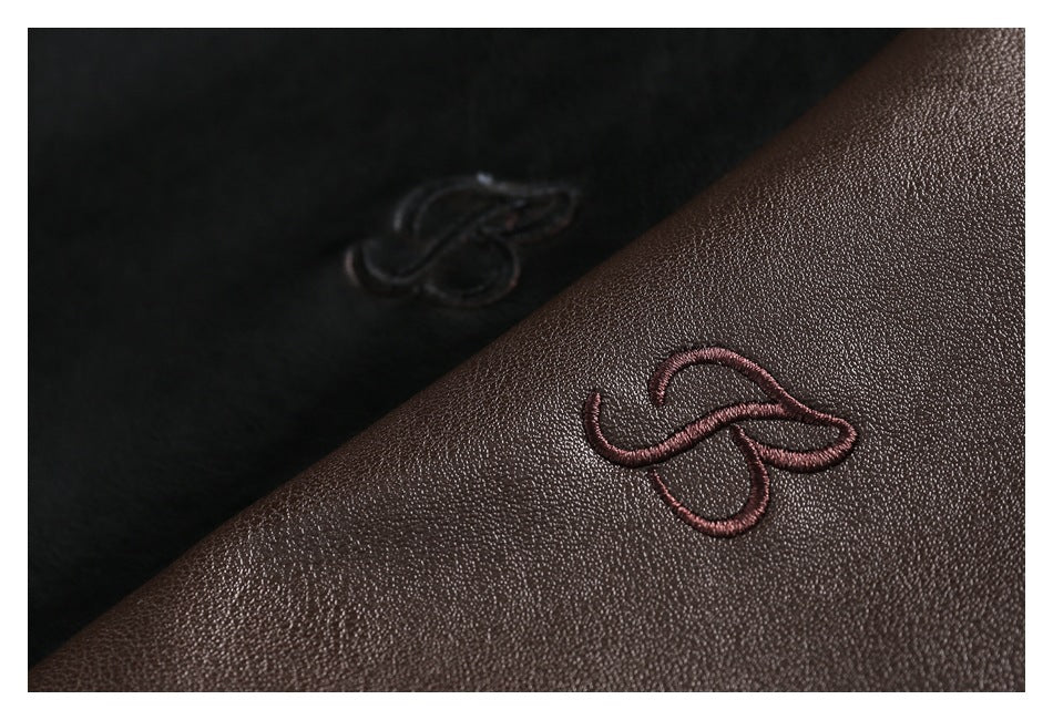 Close-up of a dark brown garment with a small embroidered loop emblem on pebbled material.