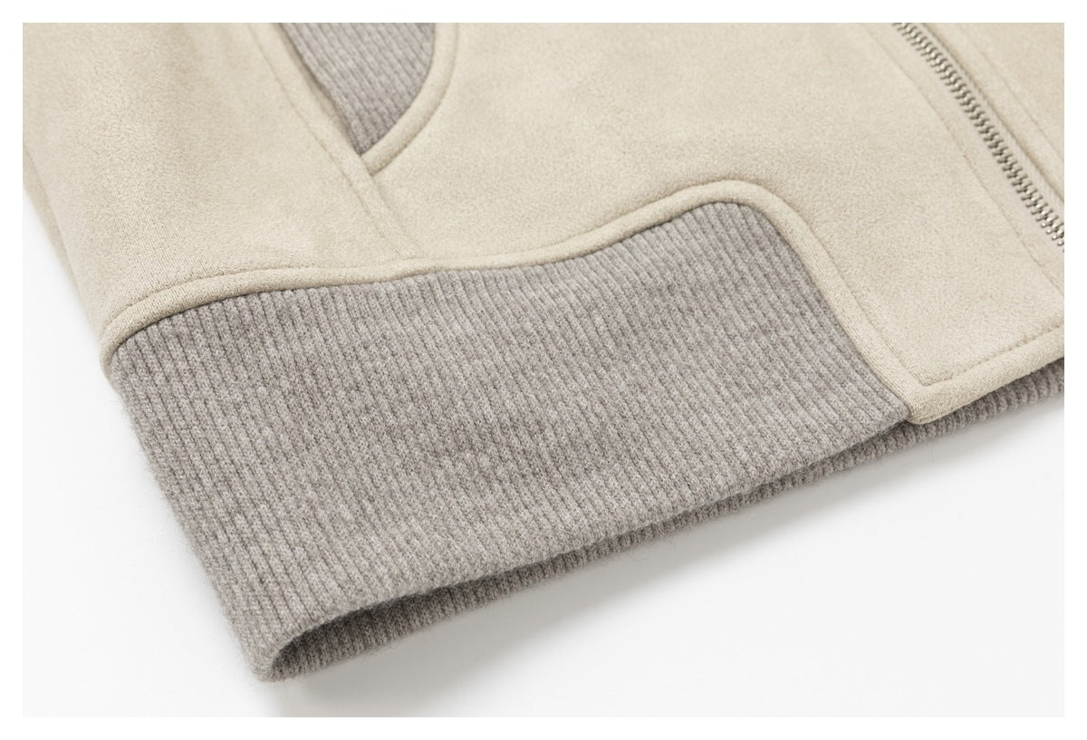 Close-up of the jacket's wide gray ribbed hem and cream fabric trim, with part of the zipper visible.