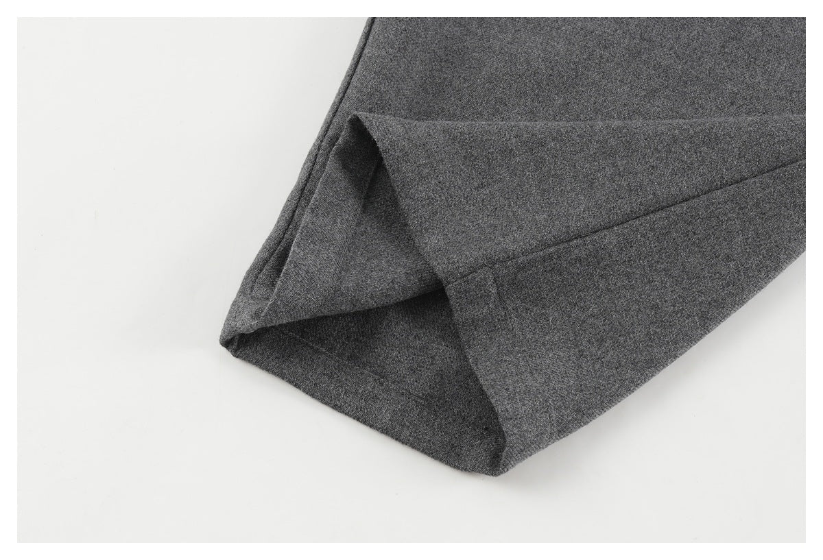 Close-up of a charcoal gray pant leg with the hem folded back to show the inside seam.