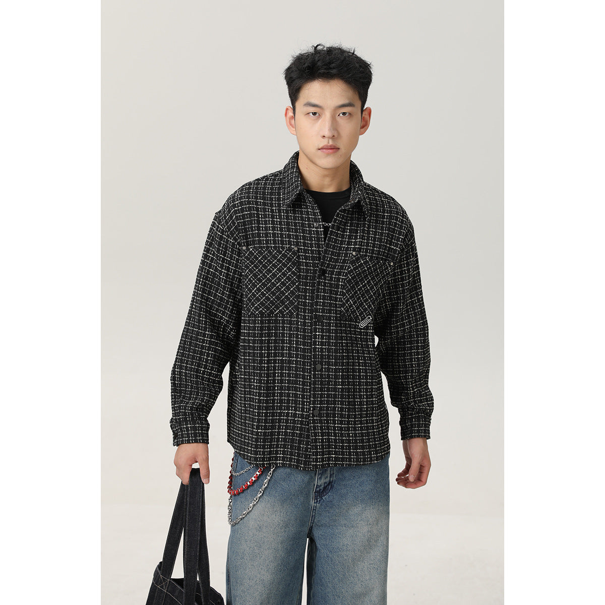 Front view of a model wearing a black-and-white grid overshirt with two chest pockets and snap buttons.