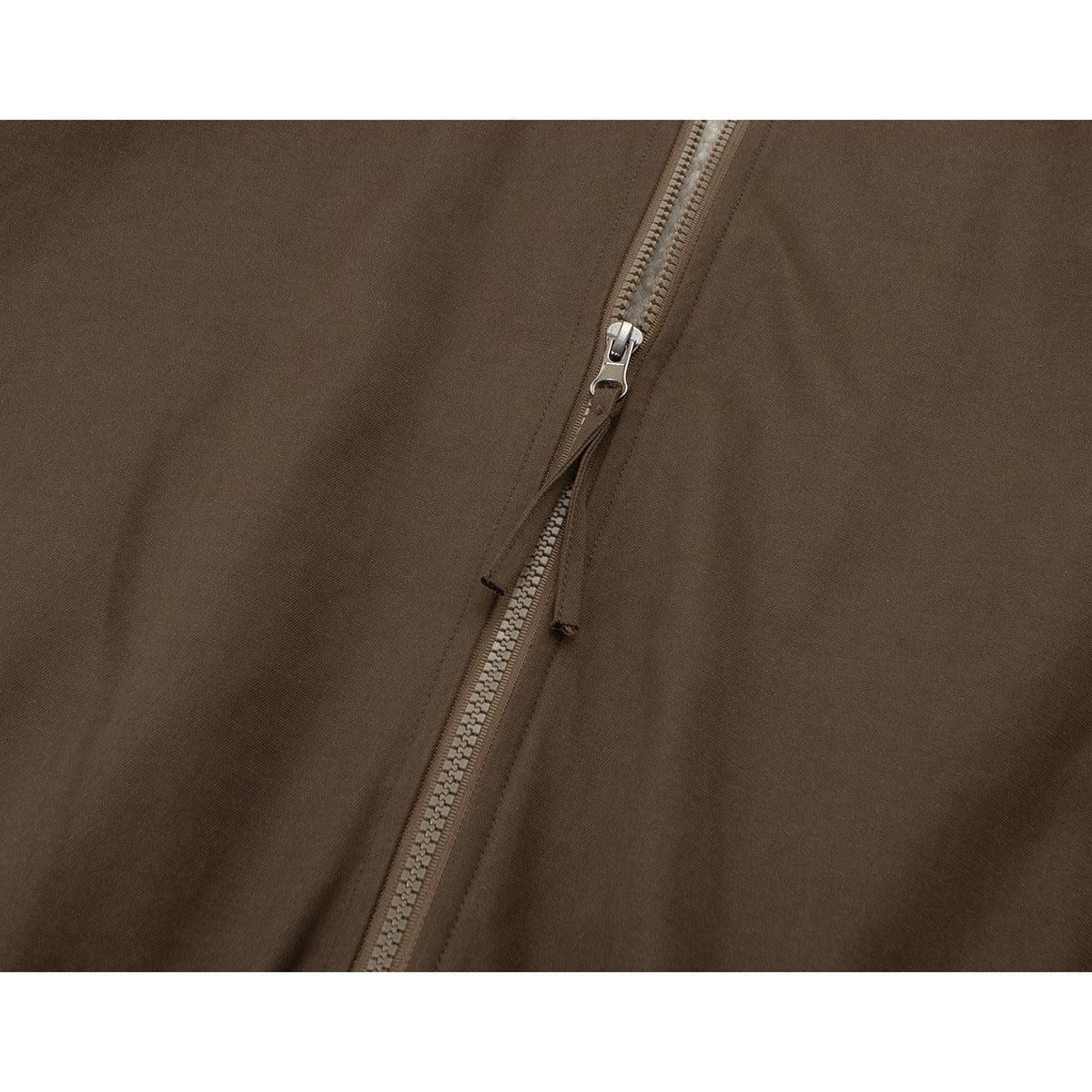 Close-up of a brown jacket's front zipper and pull.
