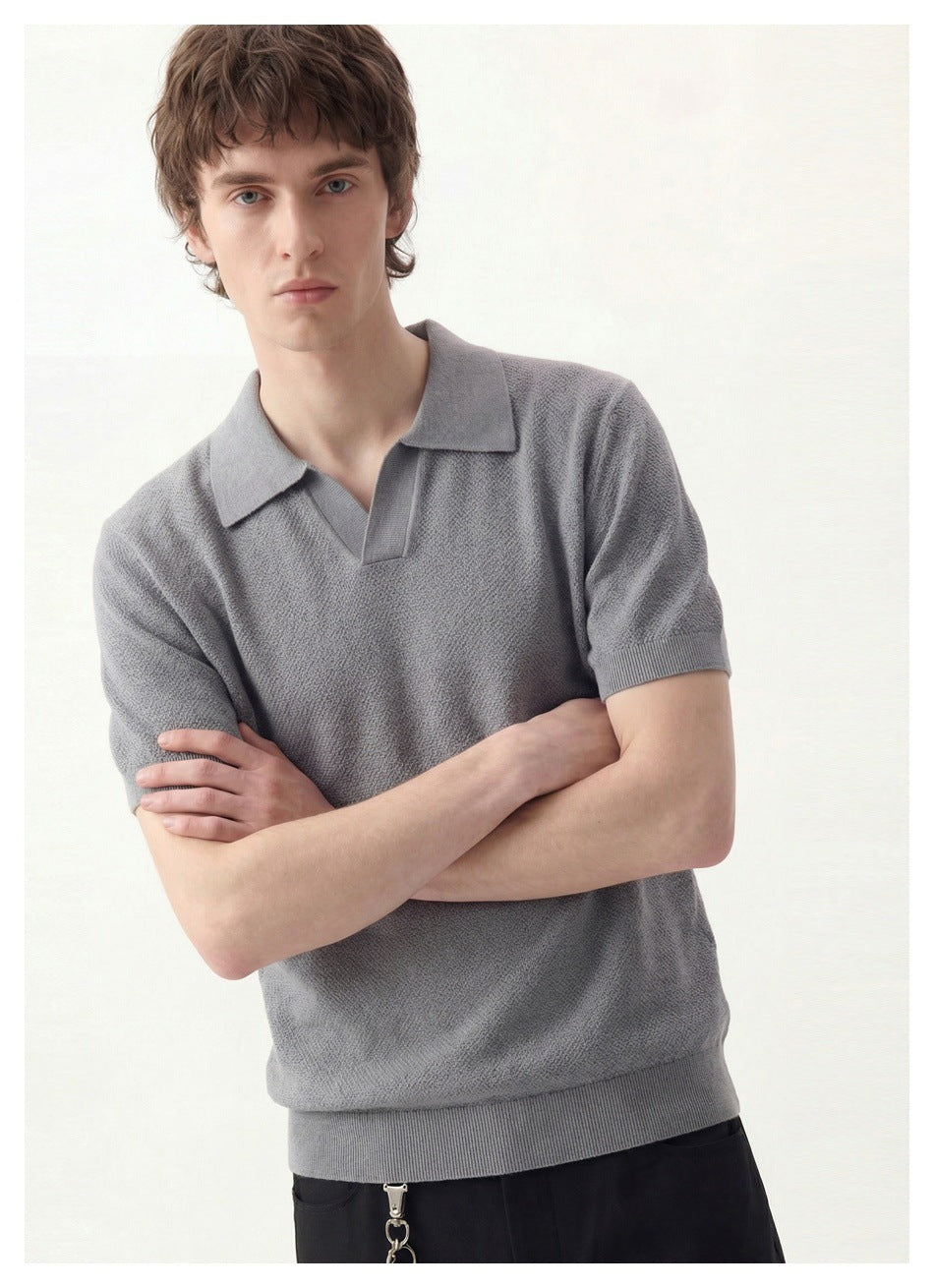Model wearing a gray short-sleeve polo with a pointed collar, V neckline, and ribbed cuffs and hem.