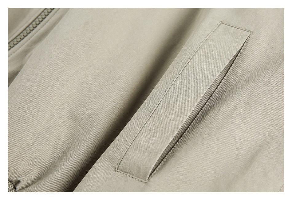 Close-up of a narrow welt pocket on the pale beige jacket.