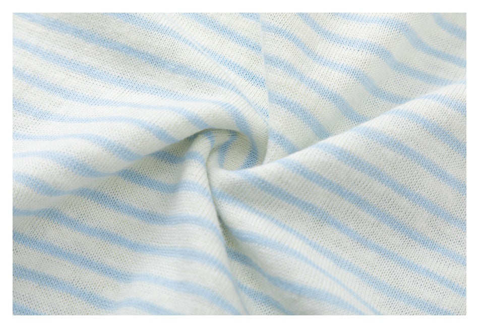 Close-up of cream knit fabric with pale blue stripes, gathered to reveal its knit texture.