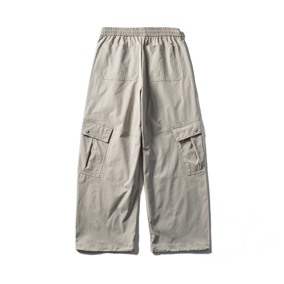 Back view of light gray wide-leg cargo pants with two rear pockets and buttoned side cargo pockets.