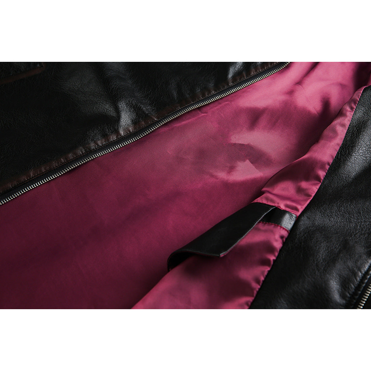 Close-up of the jacket's magenta interior lining, black outer material, and open zipper.