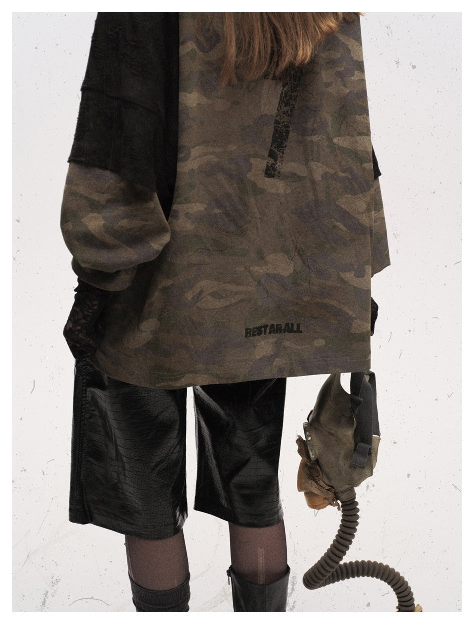 Close-up of the camouflage top's back, black sleeve panels, distressed vertical print, and small hem graphic.