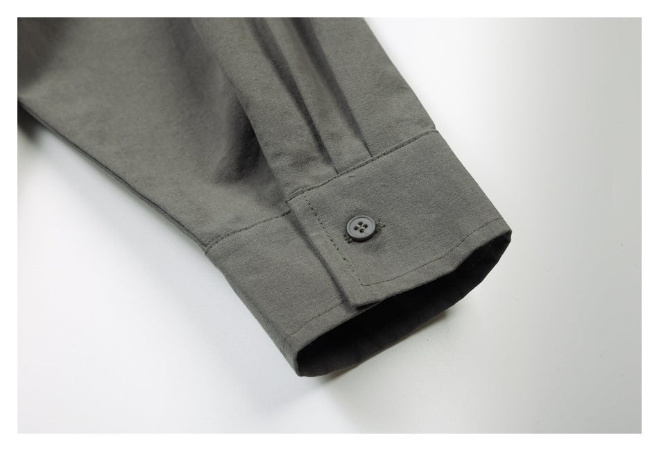 Close-up of a gray shirt sleeve cuff with a button and visible stitching.