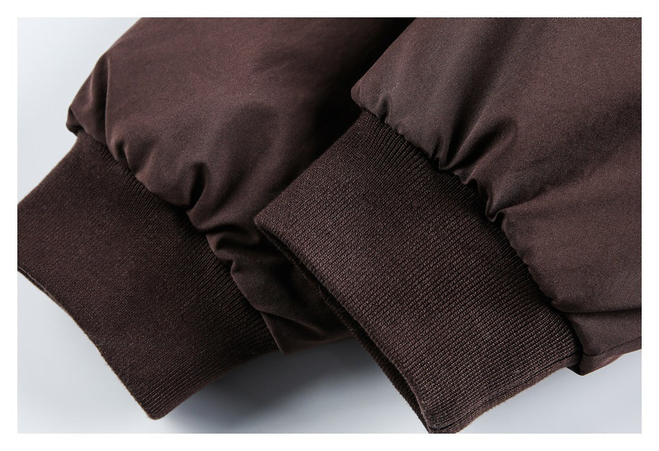 Close-up of dark brown jacket sleeves with wide ribbed knit cuffs.