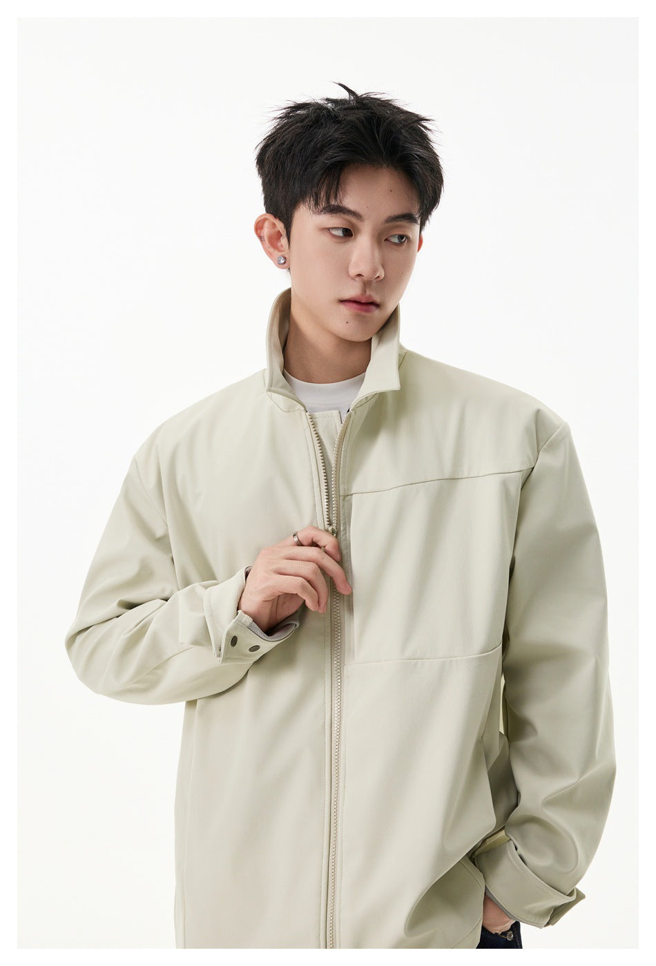 Model wearing a light beige zip-front jacket with a raised collar and buttoned cuffs.