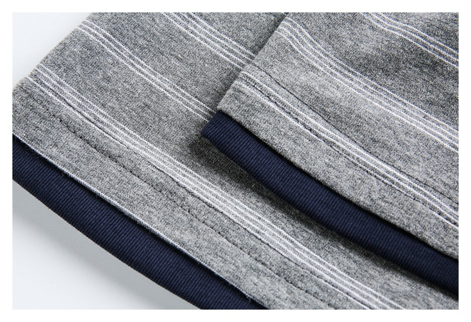 Close-up of a gray garment with thin white stripes and a navy ribbed edge.