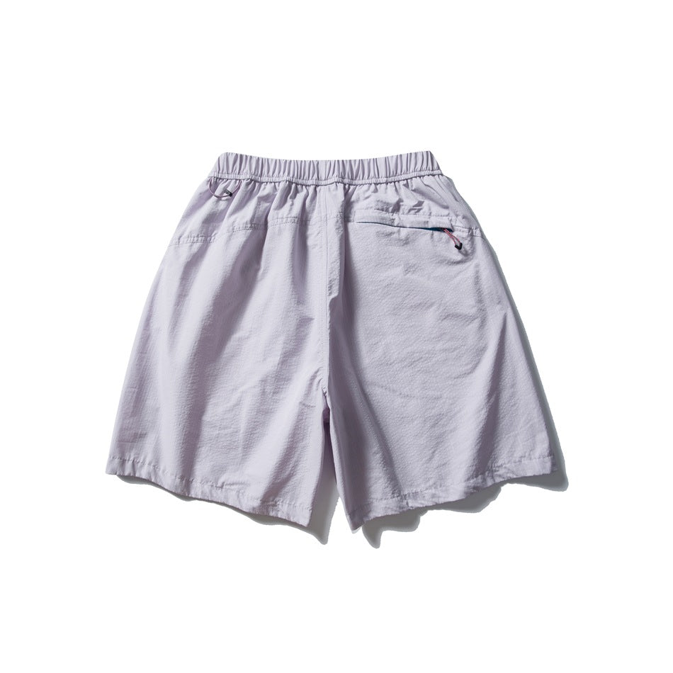 Back view of pale lavender shorts with an elastic waistband and a zip pocket.