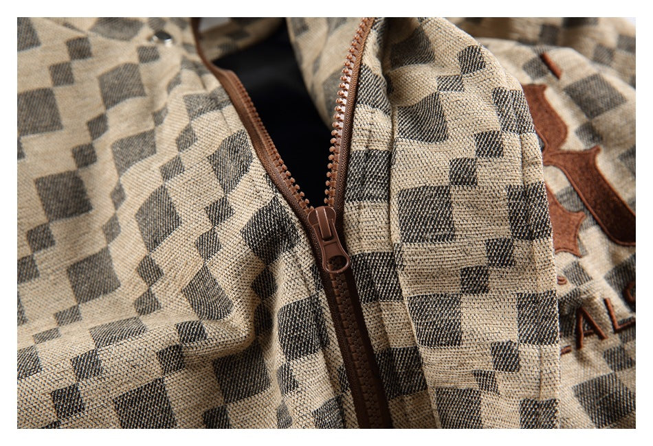 Close-up of a brown zipper on a beige and charcoal check jacket.