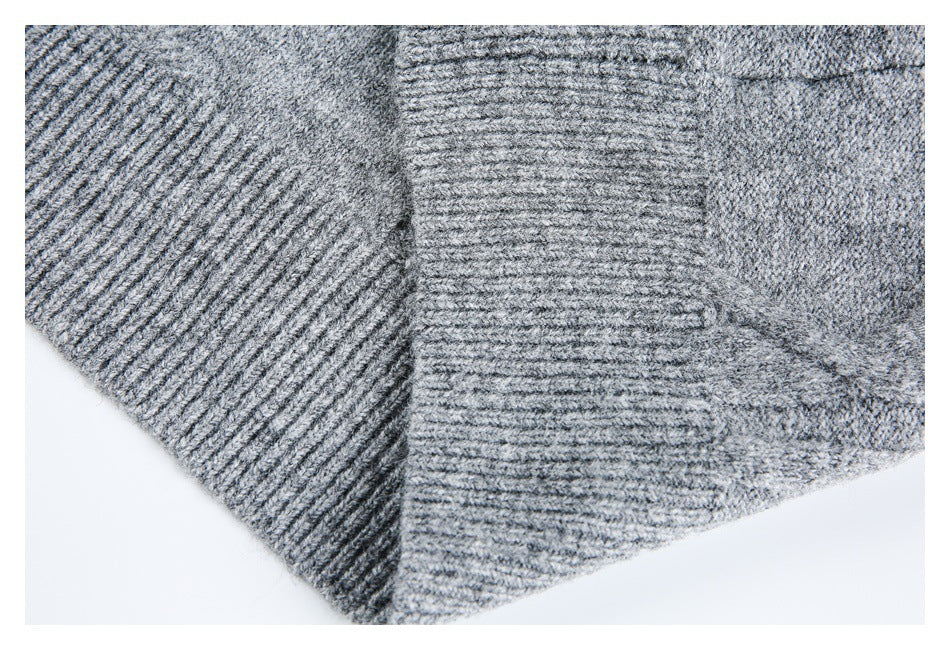 Close-up of gray knit fabric with ribbed panels meeting at a seam.