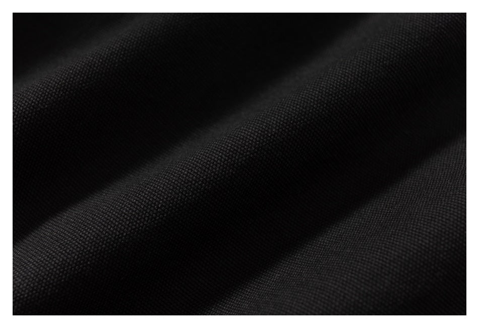 Extreme close-up of black fabric showing its textured weave and folds.