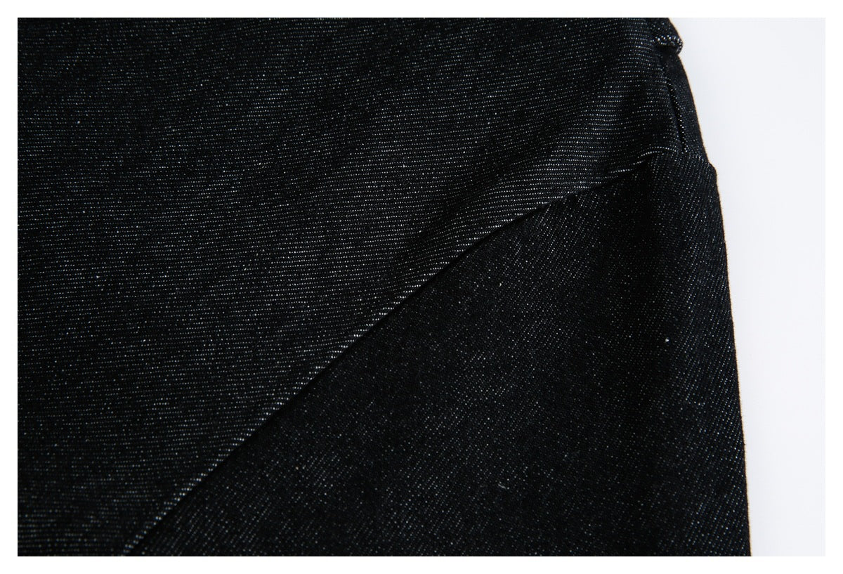 Close-up of black fabric with fine pale flecks and a curved stitched seam.