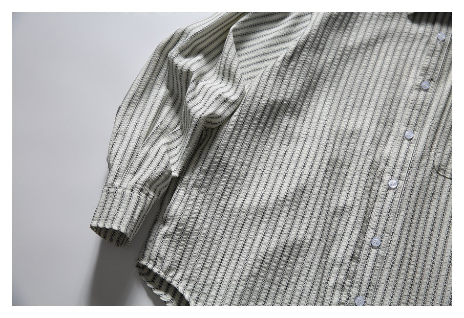 Close-up of the striped shirt's front, buttons, chest pocket edge and cuff.