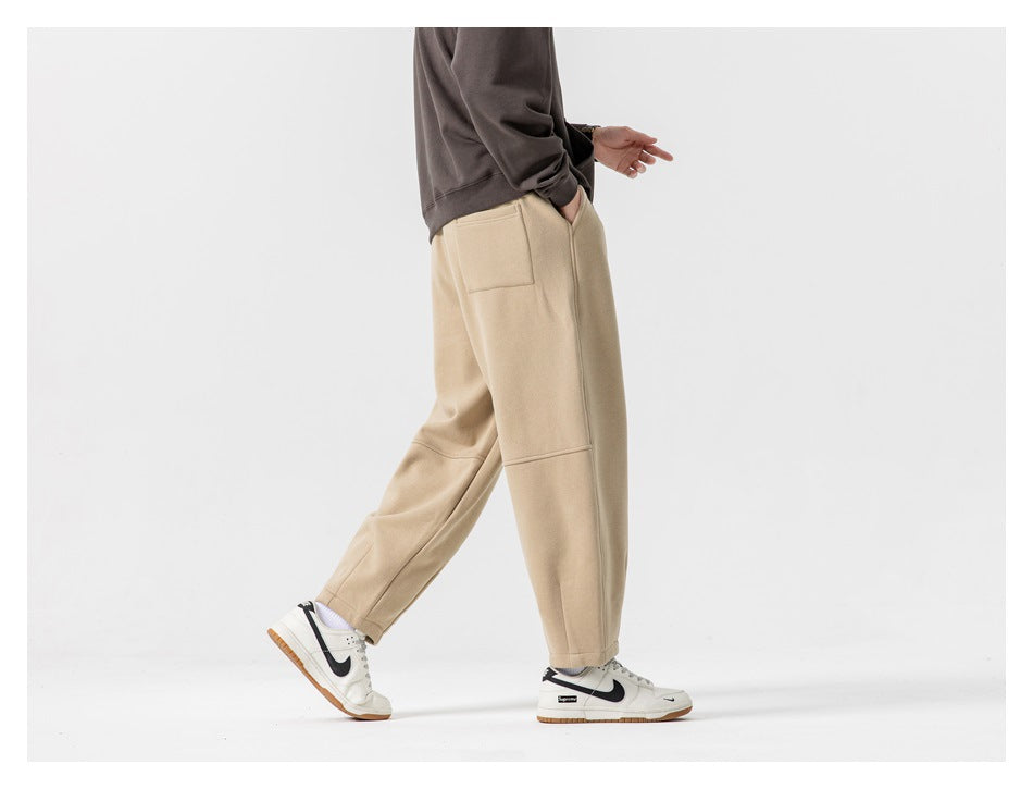 Side view of a model wearing beige joggers, showing the side seam and upper patch pocket.