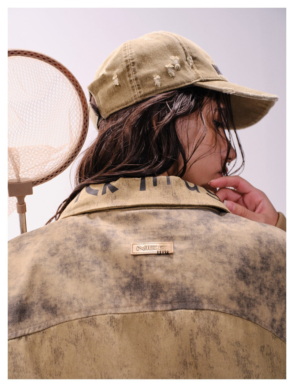 Close rear view of a model wearing a distressed tan cap and the mottled brown jacket with a small back patch.
