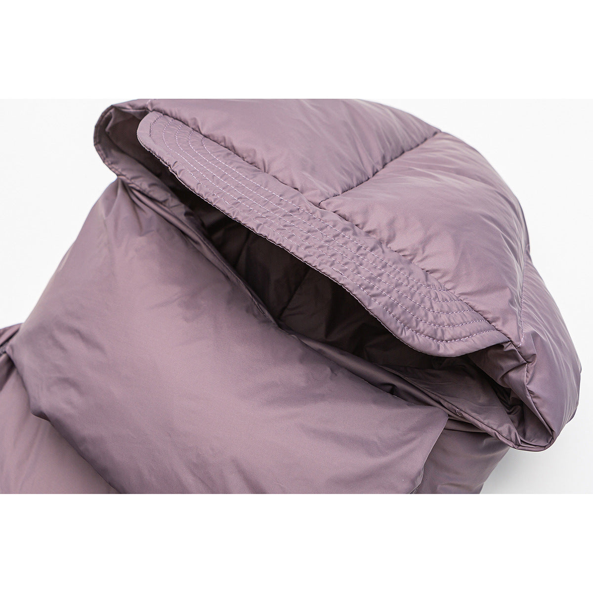 Close-up of a mauve puffer jacket hood with curved stitching and a raised edge.