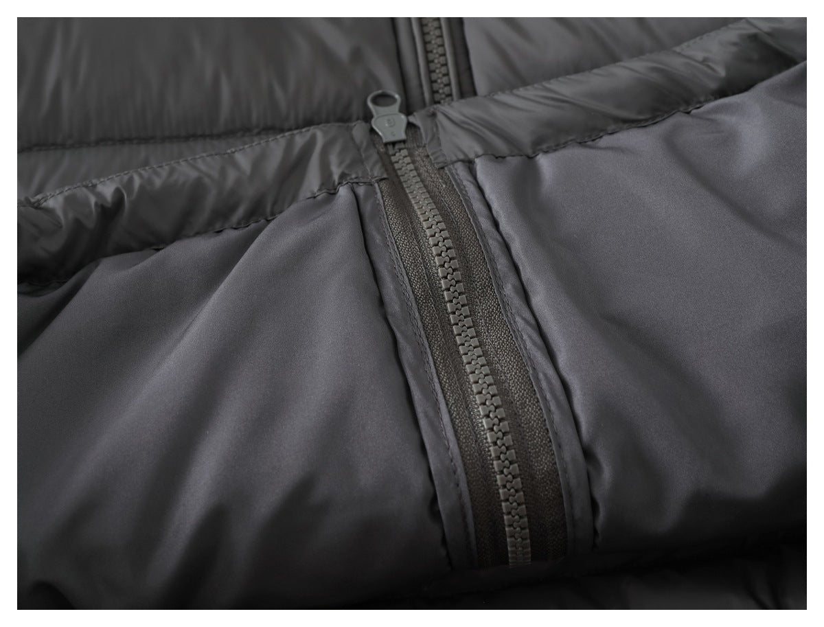 Close-up of a charcoal jacket zipper and adjoining smooth fabric panels.