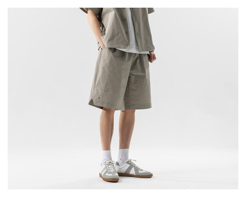 Cropped model in a taupe shirt and matching shorts, shown at a slight angle.