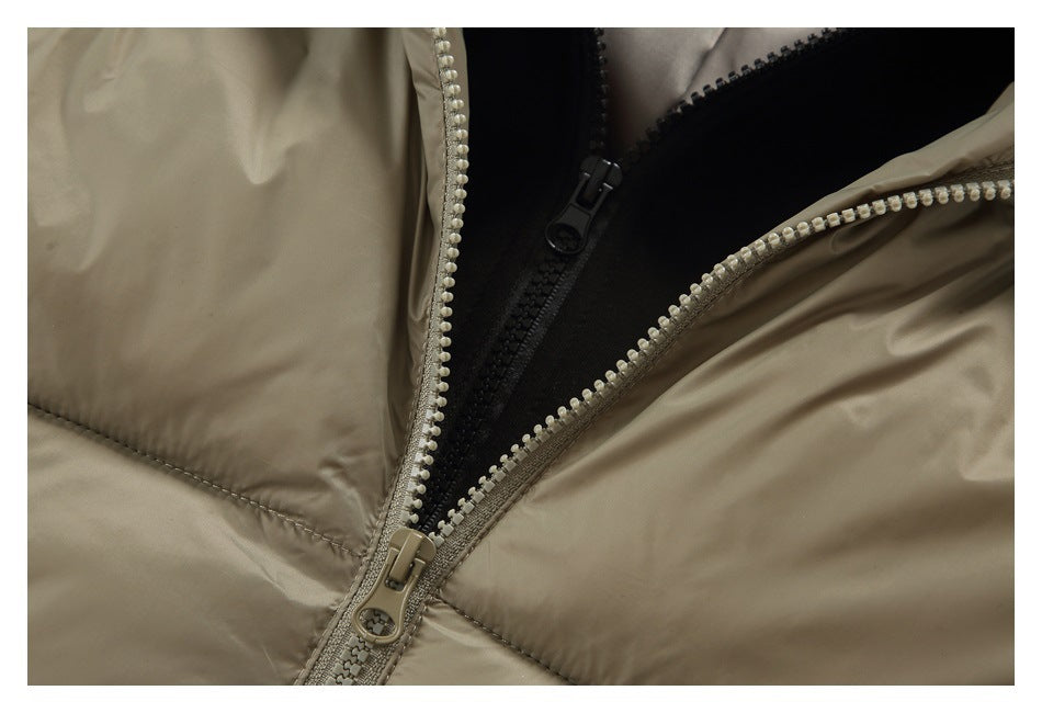 Close-up of the taupe puffer jacket’s front zipper and layered black inner closure.