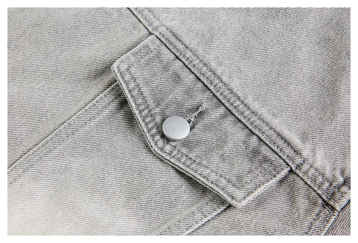 Close-up of a rectangular denim tab fastened with a round silver button.